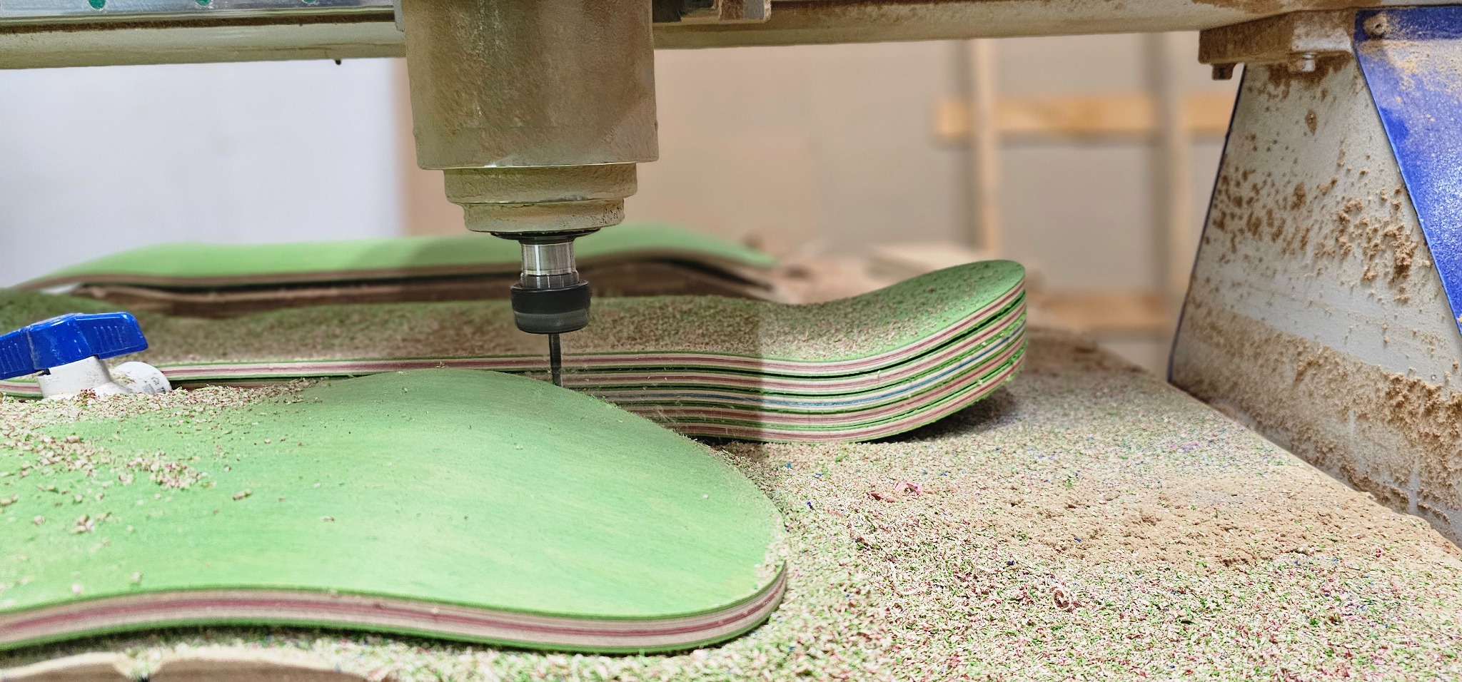 CNC trimming a skateboard nose using a production jig
