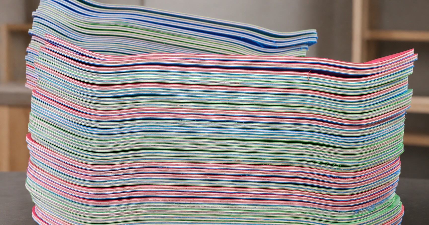 Stack of production skateboard decks against a clean shop background
